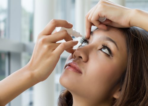 woman using eye drop, eye lubricant to treat dry eye or allergy