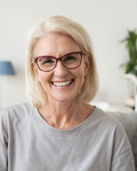 Smiling older woman wearing red framed glasses