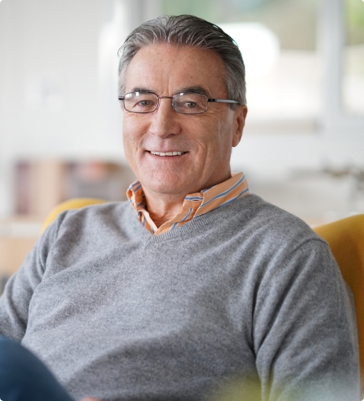 Smiling older man wearing a gray sweater
