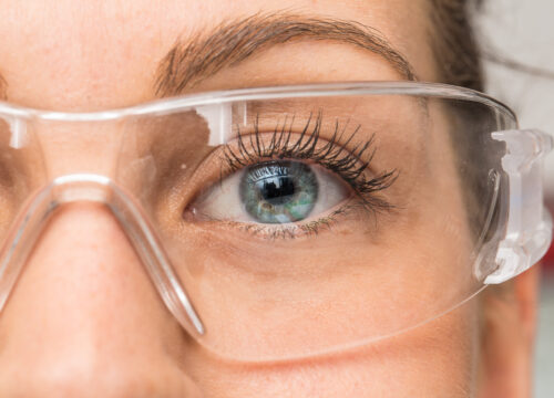 Closeup on a woman's eye wearing safety glasses
