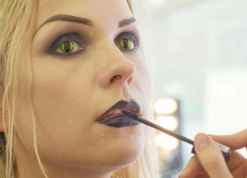 Photo of a woman getting Halloween makeup applied