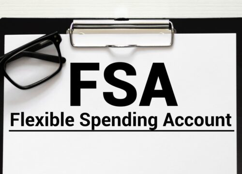 Photo of a clipboard and eye glasses. The paper on the clipboard says FSA Flexible Spending Account
